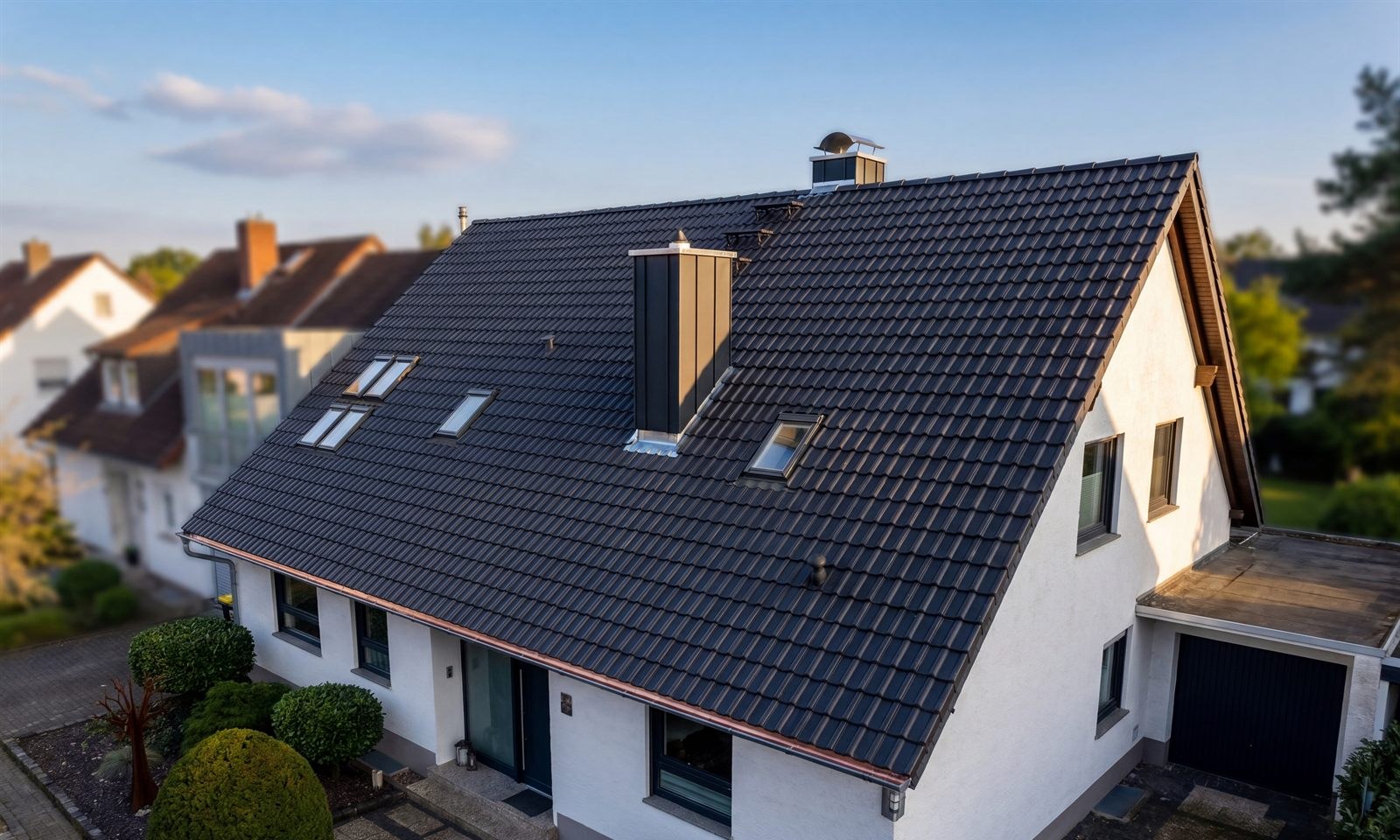 Saniertes Einfamilienhaus mit dunklem Ziegeldach aus der Vogelperspektive